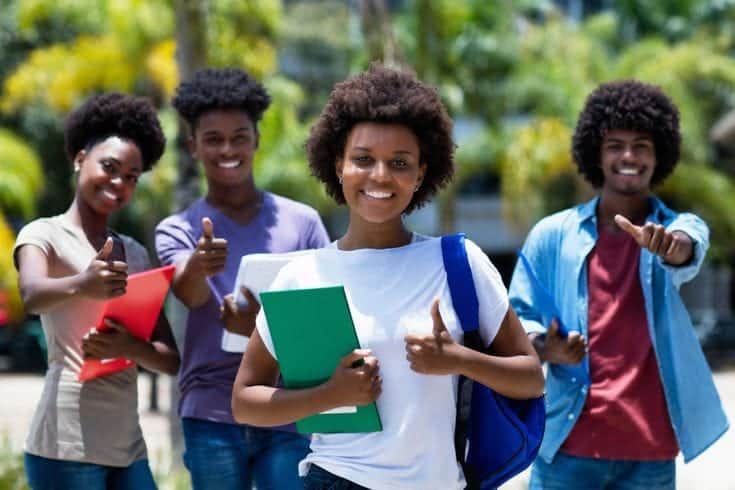 Groupe d’étudiants sur un campus, livres à la main