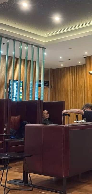 Salon d’attente d’un aéroport, écrans d’affichage des vols au fond